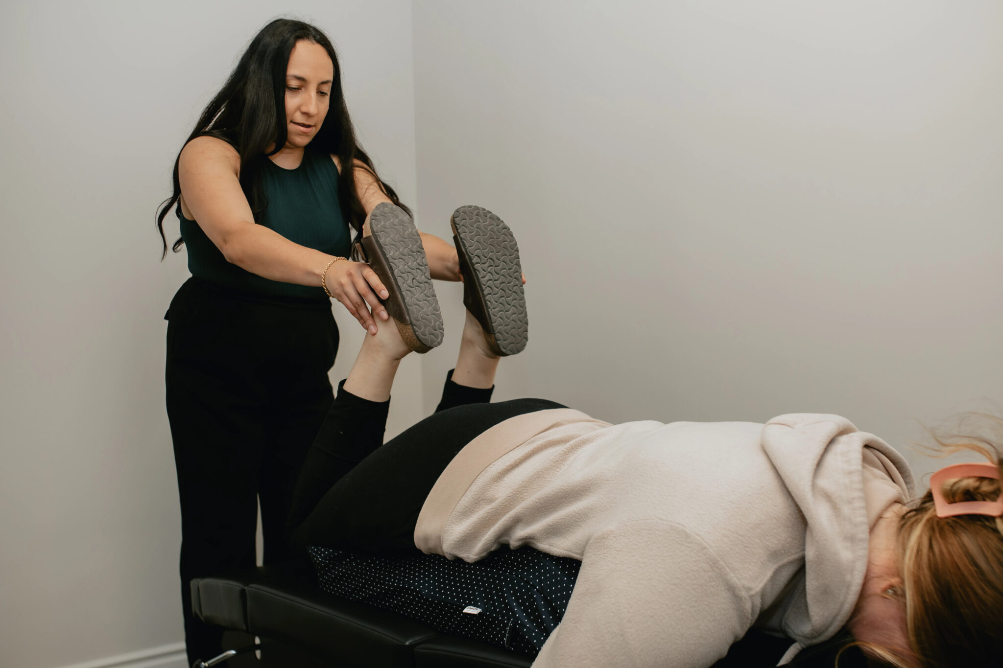 A woman is being helped by a physiotherapist in a London chiropractic & massage practice.