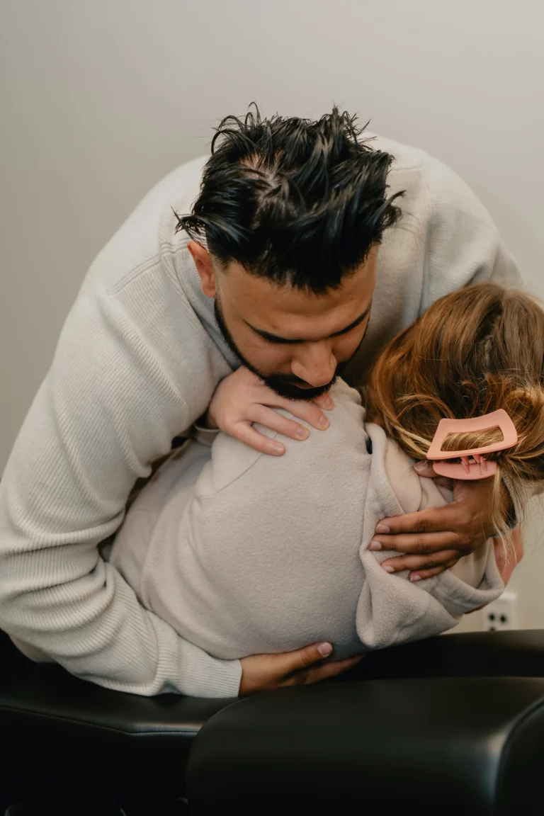 A man hugging a young girl in a chiropractic office.