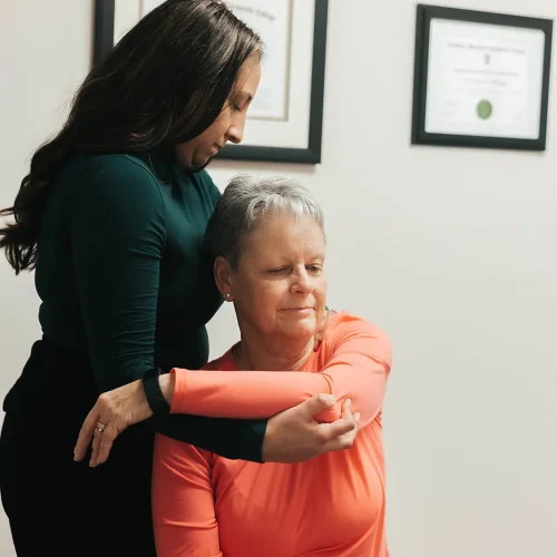 A woman is being helped by a physical therapist.