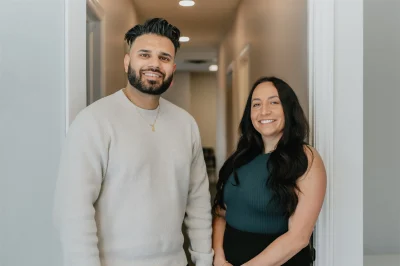 A man and woman standing in a hallway.